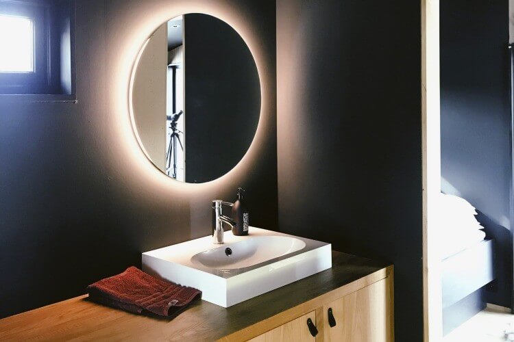 Bathroom with black walls and wooden cabinets